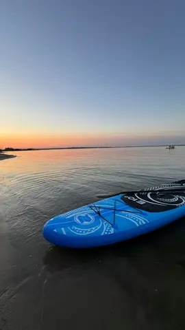 Deska SUP na plaży o zachodzie słońca